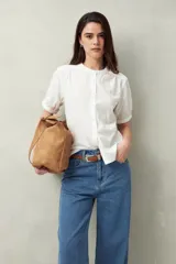 Camisa blanca de manga corta abullonada, cuello mao y botones forrados.