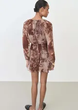 Vestido corto de gasa con estampado animal print, cuello redondo, manga larga y forro interior.