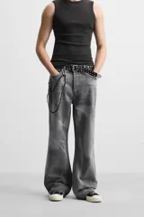 Pantalón de jean gris de corte flare, con cinco bolsillos, lavado con efecto de contraste en las piernas y bajo con acabado irregular.