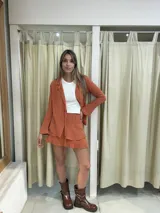 Blusa blanca de manga larga con cuello camisero y lazo en la cintura.