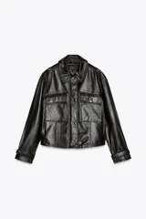 Cazadora negra de cuero con cuello solapa, manga larga con trabilla y bolsillos de parche con solapa en el delantero. Cierre frontal con cremallera y botones a presión ocultos por solapa.