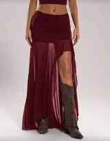 Falda larga negra de tiro bajo, con frunce en la cintura y abertura lateral. Confeccionada en tejido de red semitransparente.