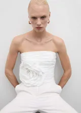 Top blanco strapless con diseño fruncido y maxi flor en el lateral.