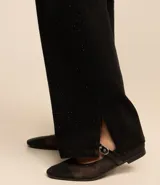 Pantalón negro de sarga con corte años 90, tiro alto, pierna recta y strass aplicados en la parte delantera.