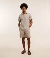 Camisa de hombre de manga corta en lino color blanco, con cuello clásico, botonadura frontal y bolsillo de parche en el pecho. Corte recto.
