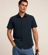 Camisa de manga corta color azul marino, abotonada en el frente y confeccionada en viscosa con fibra de bambú.