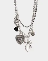 Collar corto plateado con múltiples cadenas y dijes colgantes: rosas, corazón y moño.
