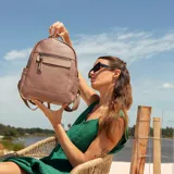 Mochila negra de símil cuero con bolsillo frontal con cierre. En su interior tiene dos bolsillos con cierre y uno abierto con división. Tiene asa de mano y correas regulables.
