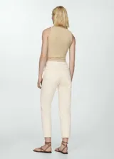 Pantalón de jean color crudo, de corte mom fit, tiro alto, cinco bolsillos y cierre con cremallera y botón.