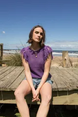 Musculosa color ladrillo de tejido calado con flecos en los hombros y cuello redondo.