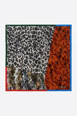 Pañuelo cuadrado de poliéster reciclado con diseño de patchwork que combina diferentes estampados animales como leopardo y serpiente. Presenta bordes en contraste de colores negro, rojo y verde.
