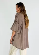 Camisa color lila con textura de lunares en relieve, de corte holgado, manga 3/4 con volados y cierre frontal con botones.