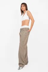 Pantalón de denim corte recto, tiro medio, color arena. Acceso con cierre metálico y botón personalizado. Cintura con cinco presillas, logo estampado en la parte trasera y bolsillos laterales con remaches. Lavado artesanal con matizado color arena. Los tonos pueden variar.