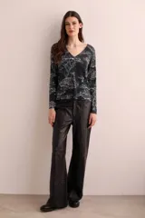 Sweater negro con estampado de tigres y árboles en blanco, cuello en V y mangas largas.