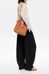 Bolso de mano negro de nailon con estructura blanda, doble asa de mano y asa de tejido regulable. Cuenta con logo metálico BIMBA Y LOLA, acabados metálicos, bolsillo interior, cierre de cordón e interior con etiqueta de tejido.