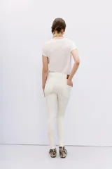 Jean blanco de tiro alto, calce skinny y pierna al cuerpo hasta el tobillo. Con proceso de coating de acabado símil cuero.