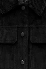 Chaqueta corta de pana negra con cuello solapa, manga larga con puños y bolsillos de parche con solapa en el delantero. Cierre frontal con botones a presión.
