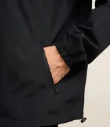 Campera rompevientos color verde oliva, con capucha ajustable con cordón, cierre frontal con cremallera, bolsillos laterales con cremallera y puños elásticos.