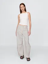 Pantalón de jean de tiro alto con estampado a rayas verticales en color beige y negro.