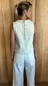 Chaleco color crudo con cuello redondo y costuras a la vista.