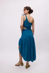 Vestido largo rojo de algodón y lino, con un hombro descubierto, bretel fino con lazo, recorte en la cintura y falda asimétrica con volados.