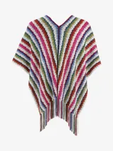 Poncho de punto multicolor con diseño de rayas verticales en zigzag y flecos en el borde inferior.