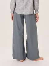 Pantalón ancho de algodón color verde militar, con corte holgado, pinzas debajo de la rodilla y pespuntes a contratono. Presenta un bordado de monograma en el bolsillo delantero.