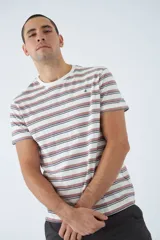 Remera de algodón a rayas horizontales en tonos blanco, marrón y rojo. Tiene cuello redondo, mangas cortas, corte regular y logo estampado en el pecho.