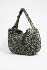 Bolso shopper de nylon con estampado animal print en tonos verde y negro. Tiene doble asa de mano, asa de tejido, bolsillo interior y etiqueta cerillera.