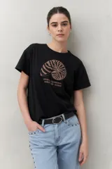 Remera negra de manga corta con estampado de una concha marina y texto en color marrón.