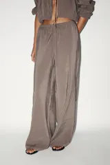 Pantalón palazzo color gris topo de tejido fluido, con cintura elástica ajustable con cordones y bolsillos laterales.