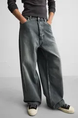 Pantalón de jean negro de corte amplio, con cinco bolsillos, efecto lavado y cierre frontal con cremallera y botón.
