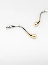 Pendientes alargados para mujer con diseño de gota estilizada y acabado bicolor en tonos dorado y plateado. Poseen cierre de broche.