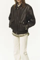 Chaqueta bomber de cuero marrón oscuro con cuello clásico, cierre frontal con botones a presión, bolsillos con solapa y puños y cintura acanalados.