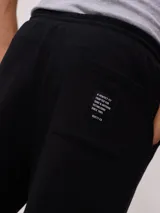Bermuda deportiva gris confeccionada en 60% algodón y 40% poliéster, con cintura elástica ajustable con cordón.