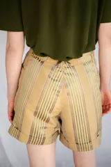 Short unisex color verde con rayas verticales, tiro alto, pinzas y bolsillos.