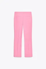 Pantalón color arena de tiro alto con bolsillos delanteros y corte acampanado. Cierre frontal con cremallera y gancho metálico.