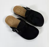 Sandalias negras con hebilla metálica ajustable y plantilla color beige.