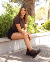 Botinetas de cuero marrón con acabado desgastado, diseño de caña baja con cierre frontal y dos correas con hebillas metálicas. Presentan una suela track robusta y antideslizante.