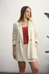 Blazer celeste de lino con solapas de muesca, cierre cruzado con botones, bolsillos delanteros con solapa y corte holgado.
