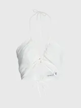 Blusa blanca con textura arrugada, escote halter y cierre anudado en la espalda.