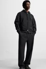 Pantalón jogger gris de corte recto, confeccionado en tejido de algodón compacto con interior en rizo. Cuenta con cintura elástica ajustable con cordón interior, bolsillos frontales y bolsillo de doble vivo en la espalda.