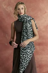 Bufanda rectangular de tejido suave color crudo con estampado animal print de leopardo en negro.