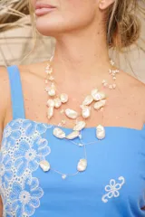 Collar de múltiples hilos finos con perlas irregulares y pequeñas cuentas blancas.
