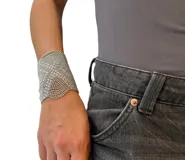Pulsera de malla metálica dorada con cierre de botón a presión.