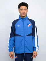 Campera deportiva Umbro del Club Nacional de Football, con cierre frontal, cuello alto y bolsillos laterales. Diseño en azul con detalles en blanco y azul marino.