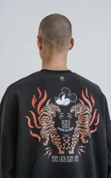 Buzo negro de frisa 100% algodón, de calce oversize y cuello redondo. Estampado pequeño en el frente del personaje Mickey Mouse enojado.