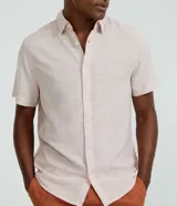 Camisa de corte regular confeccionada en mezcla de lino y algodón, con cuello inglés, manga corta y cierre frontal abotonado. Diseño liso en color beige de la marca Marfinno.