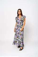 Vestido largo con estampado floral en tonos lila, verde y blanco, con escote en V, mangas cortas con volados y lazo ajustable en la cintura.