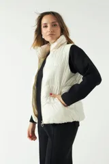 Chaleco puffer color crema con textura acolchada y bolsillos con cierre.